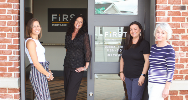 Four female bank employees standing outside of a First National Bank of Middle Tennessee Mortgage branch location.