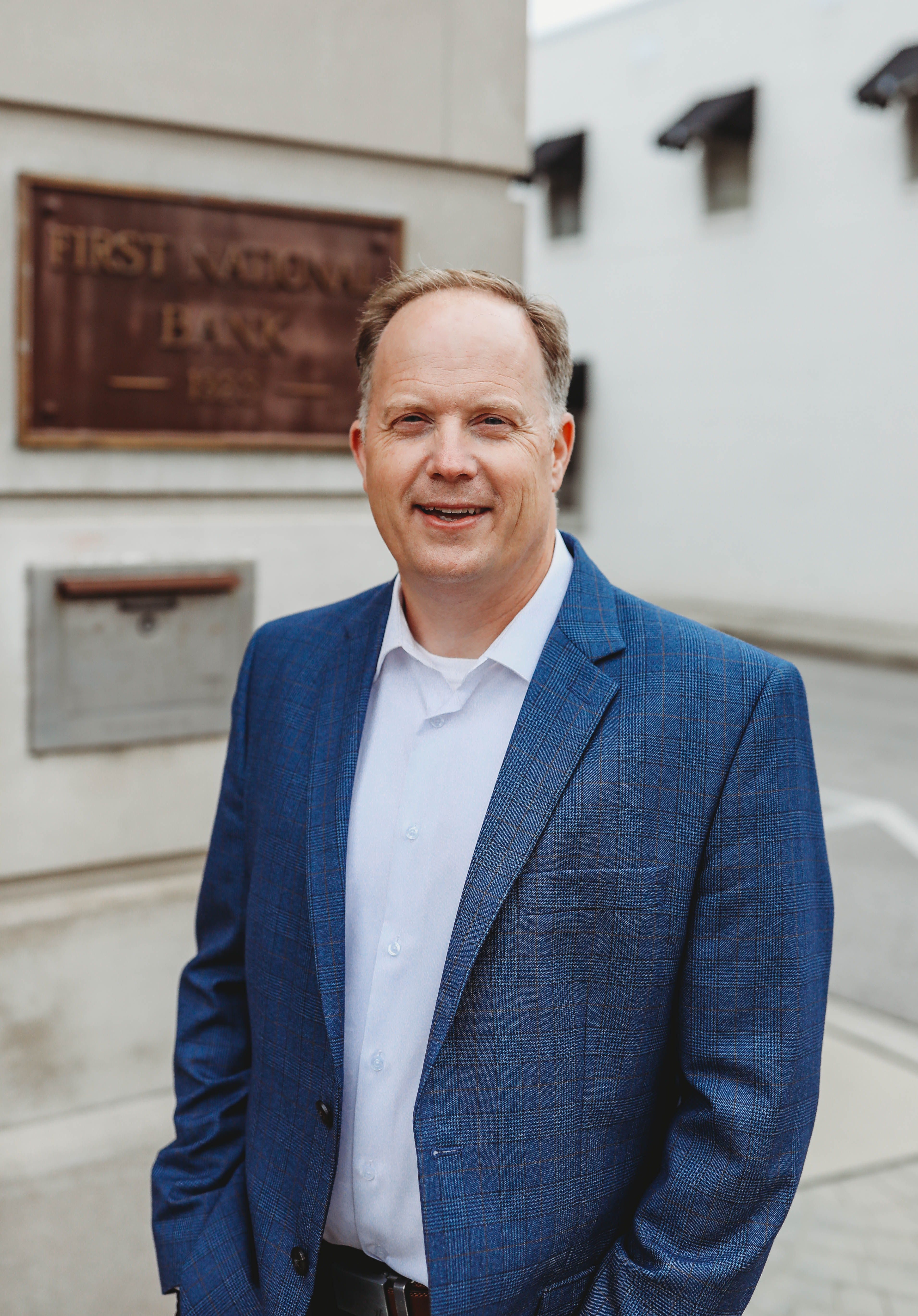 A headshot of a man standing in front of First National Bank Middle TN.