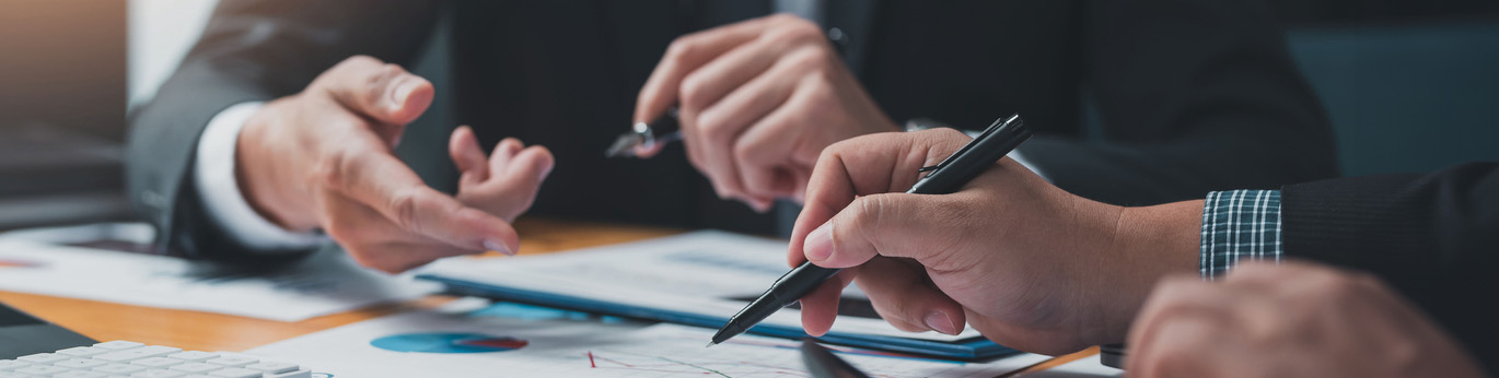 Zoomed in image of two people at a conference table looking at a chart.