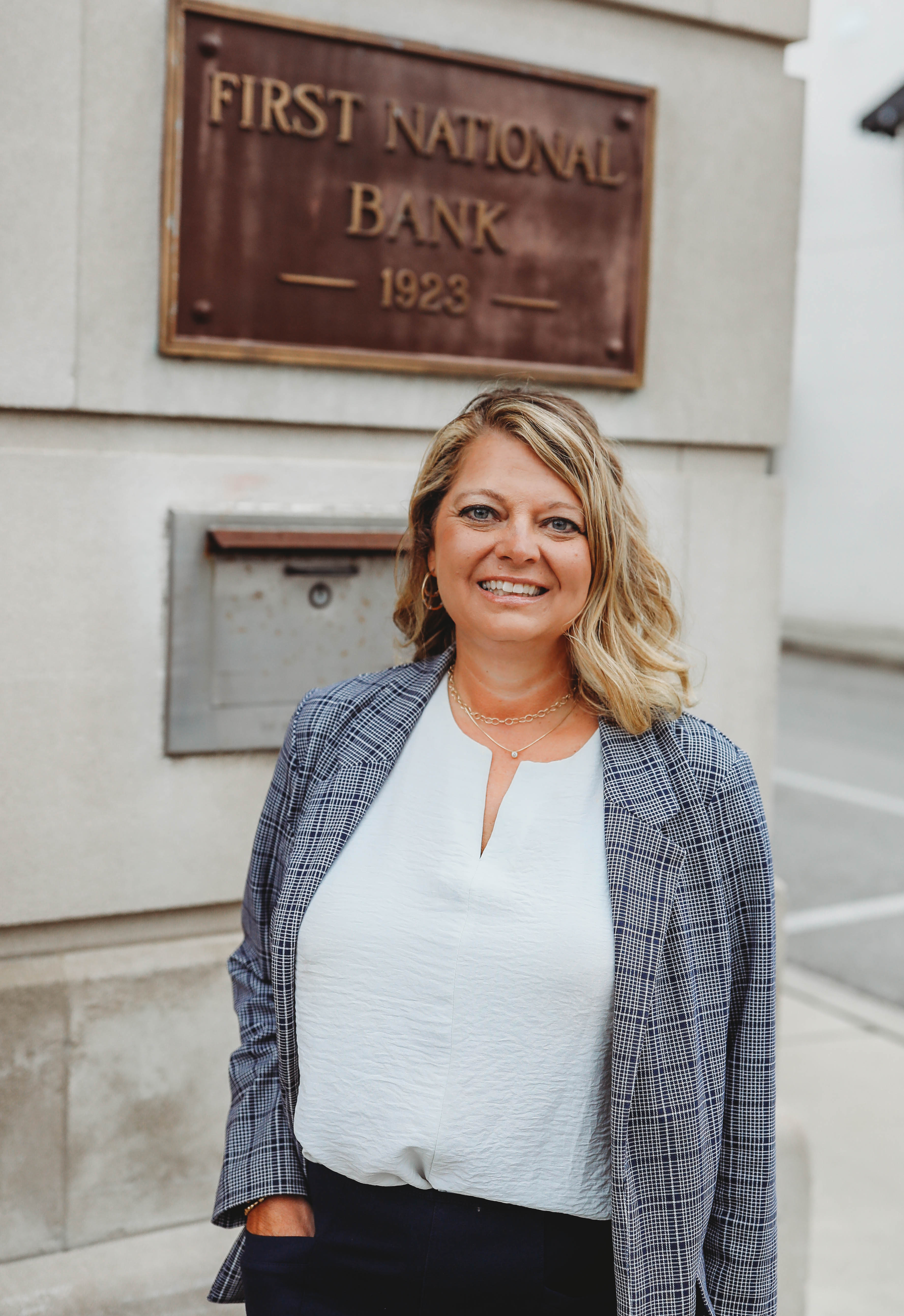 A headshot of a woman standing in front of First National Bank Middle TN.