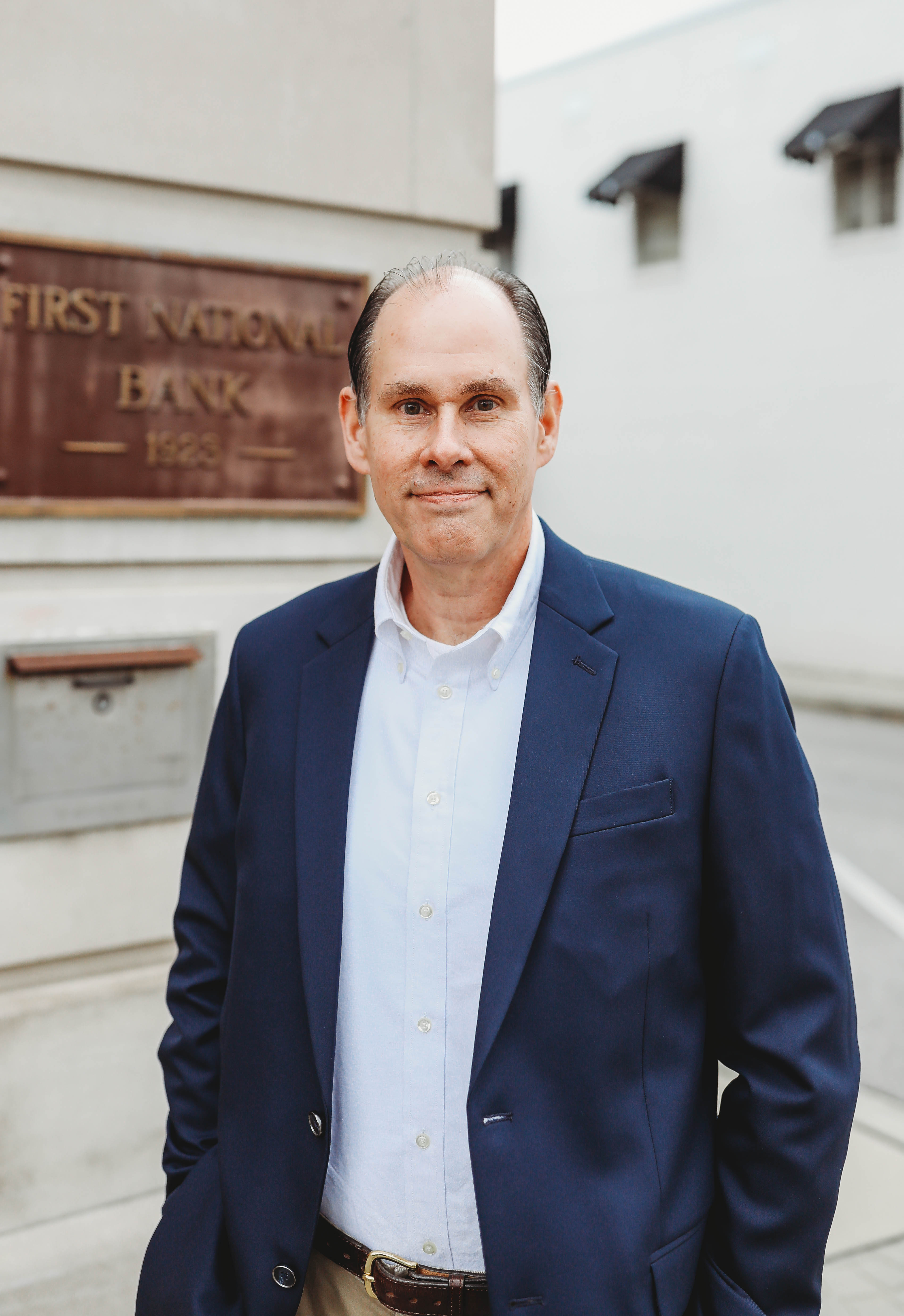 A headshot of a man standing in front of First National Bank Middle TN.