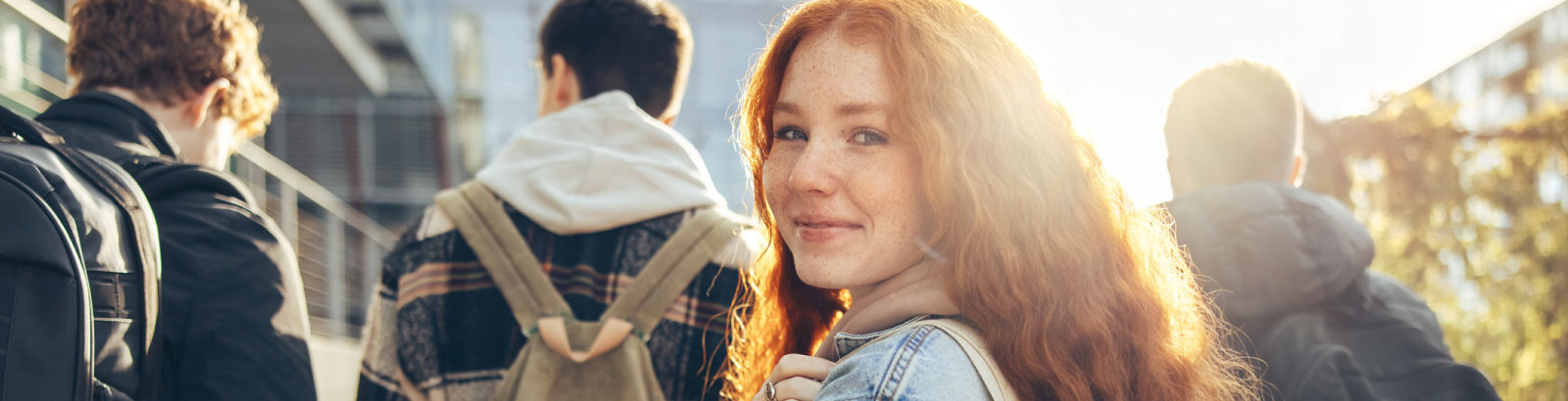 A girl at school turning around and smiling.